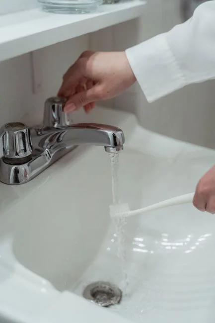 a-woman-is-cleaning-a-kitchen-sink-with-a-rag-sqomdoqb3ws