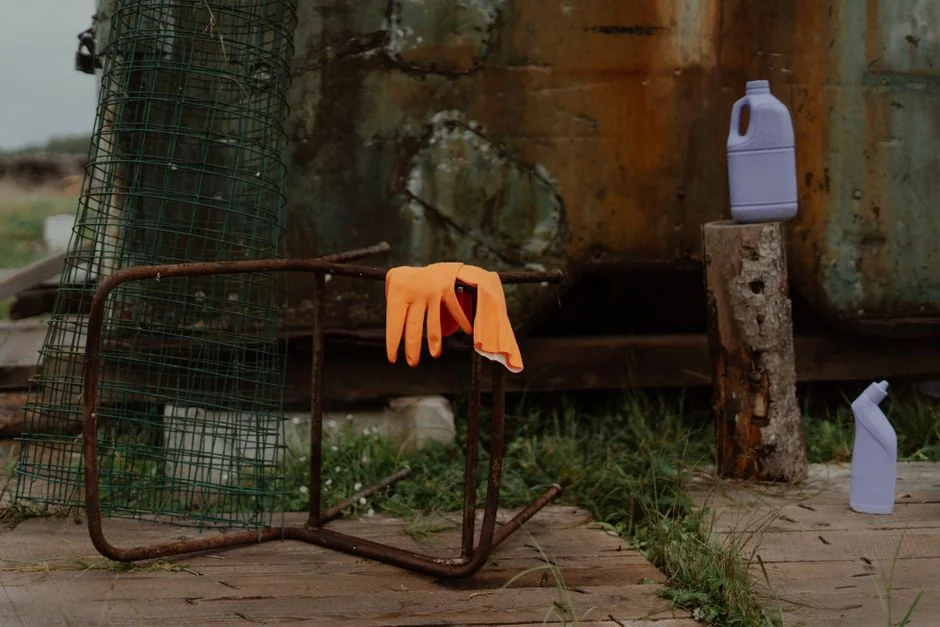 Anonymous male in yellow rubber gloves wiping foam from round mirror in bathroom